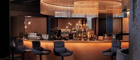 A bar area with a circular seating arrangement, a bar counter stocked with bottles, and a unique hanging light fixture.