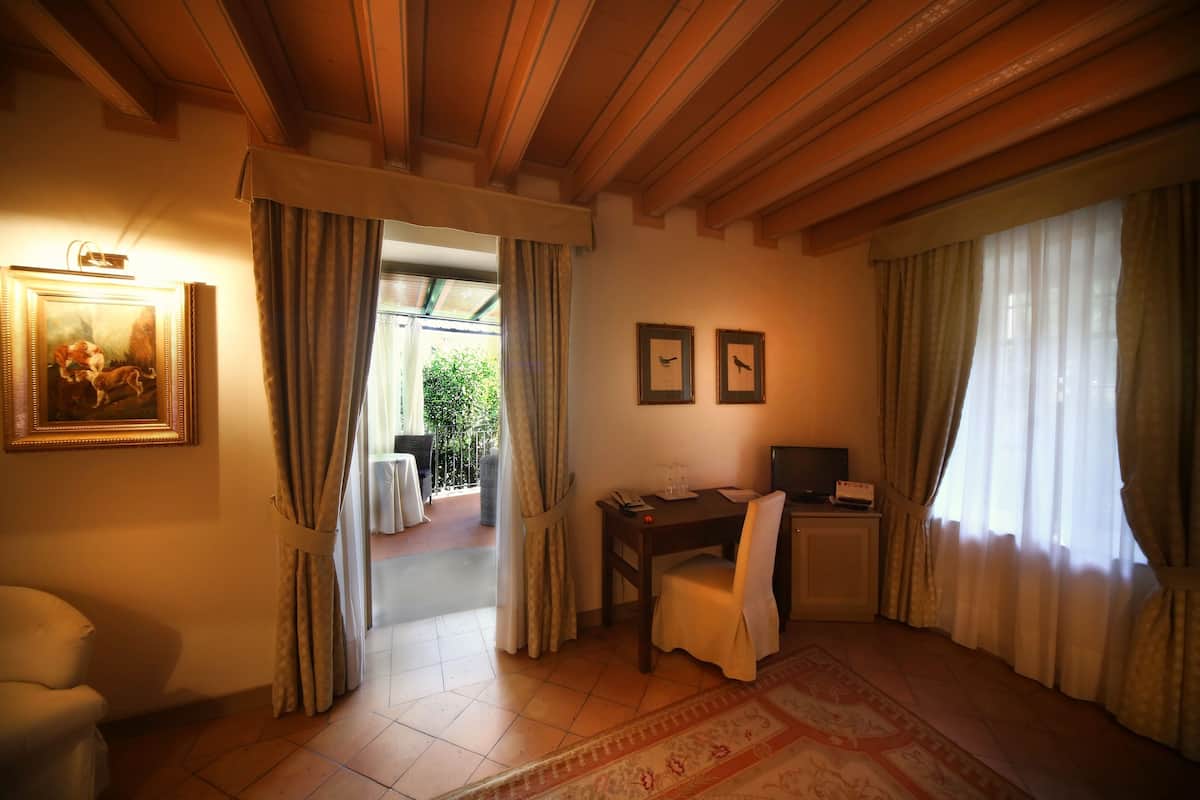 Ein Zimmer mit Holzboden, einem Esstisch mit Stühlen, einem Fernseher und einem Bild an der Wand.