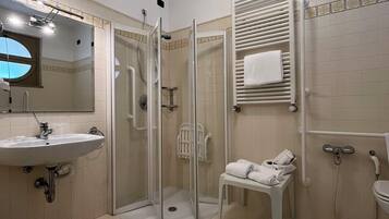 Un baño moderno con ducha de vidrio, lavamanos e inodoro.