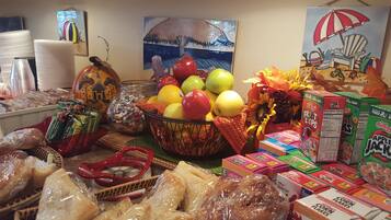 A table with various food items including fruits, packaged snacks, and bread.