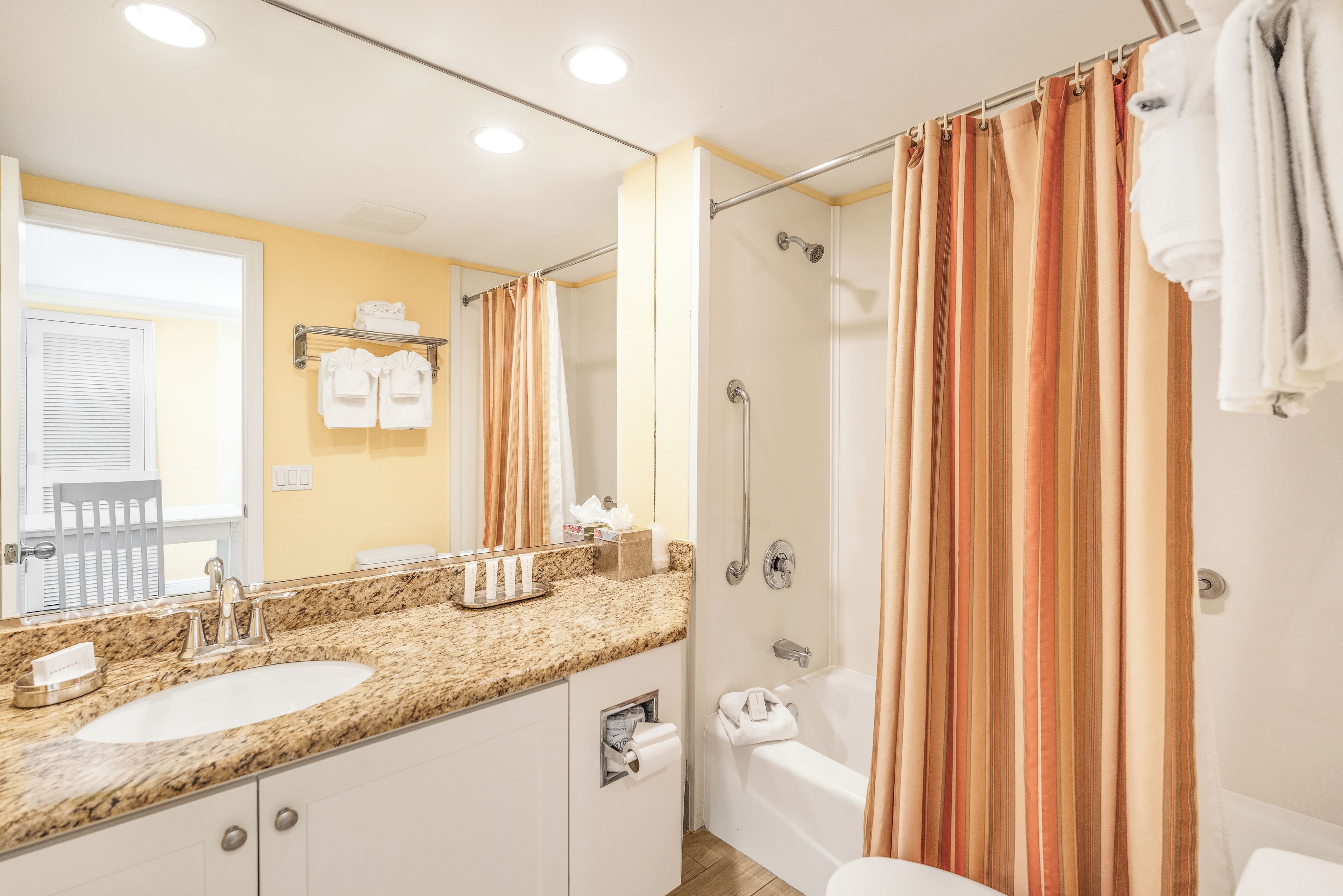 A bathroom with a sink, mirror, shower, and bathtub.