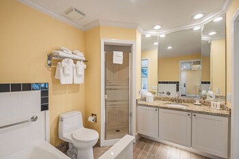 A compact living space with a dining area, kitchenette, and a television on a desk. at Inn at the Beach