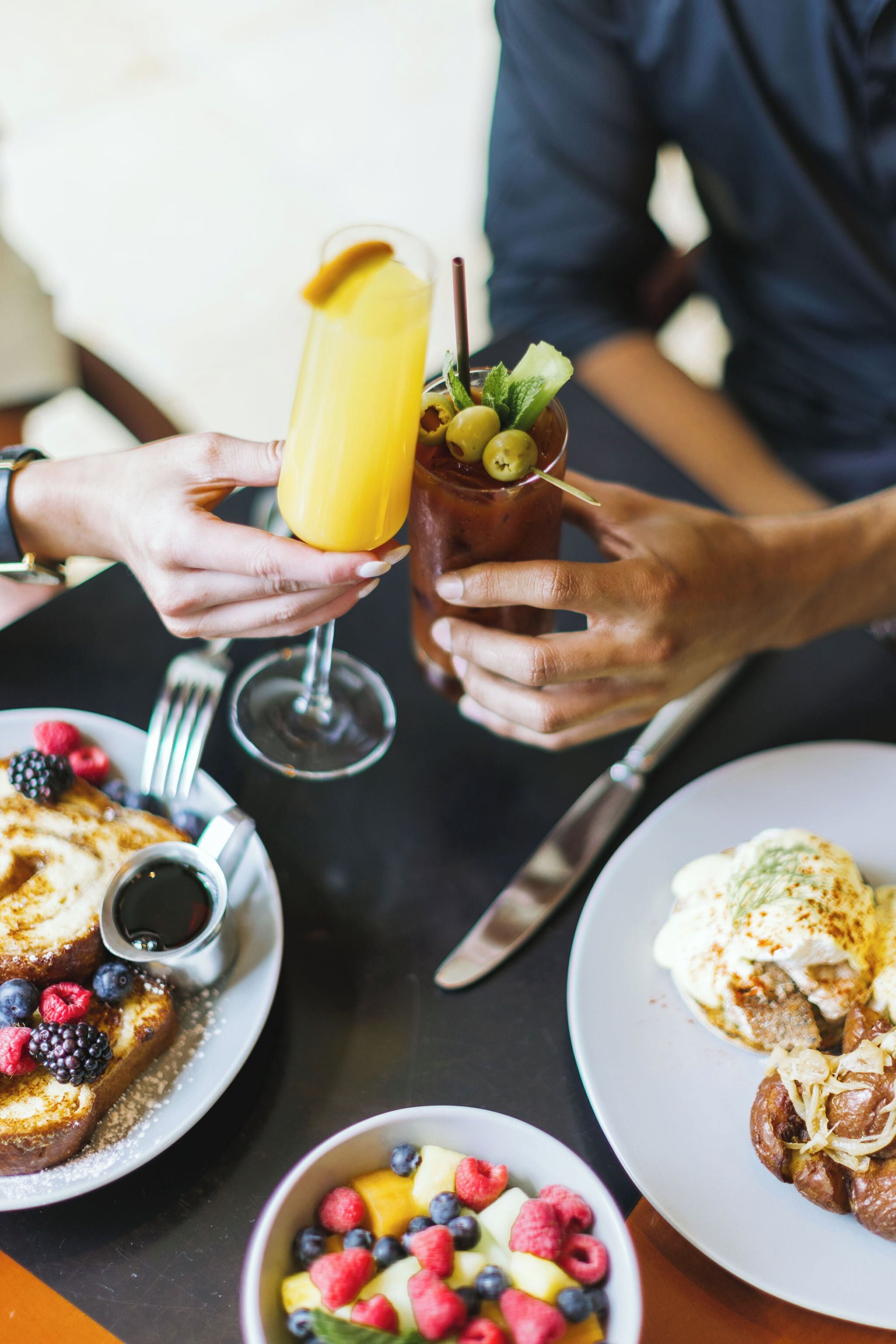 A breakfast setting with toast, fruit, and beverages on a table.