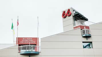 The exterior of the Bell Harbor International Conference Center with a prominent '66' sign, a balcony, and flags.