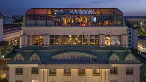 A multi-story building with a glass upper level and a lower level with large windows. - Radisson Blu Leogrand Hotel (Chisinau)
