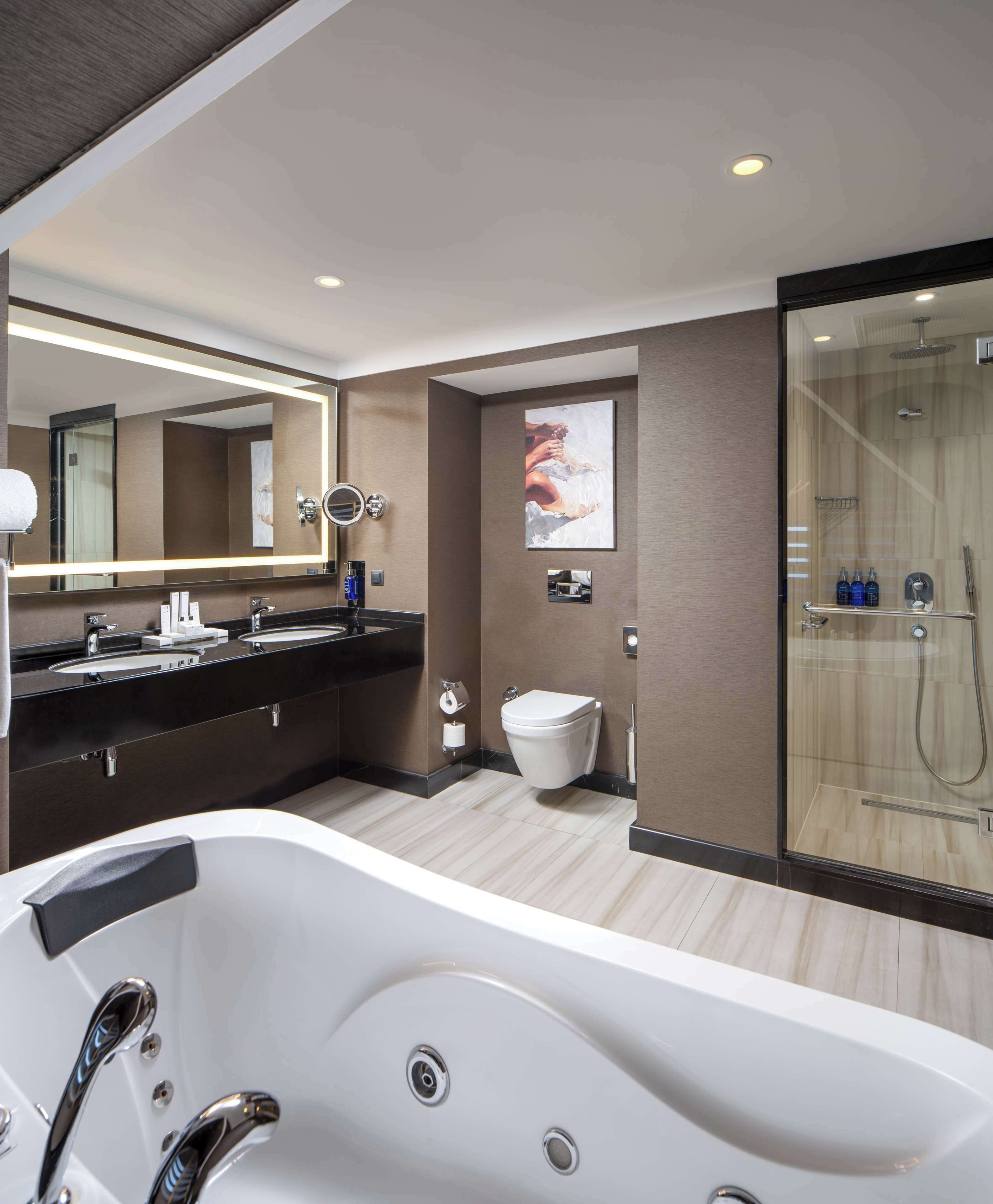 family suite | bathroom | separate bathtub and shower, rainfall showerhead, designer toiletries