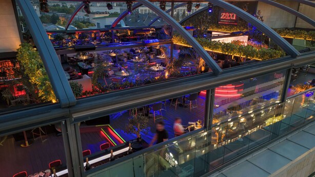 A rooftop bar with a glass balustrade overlooking a cityscape. - Radisson Blu Leogrand Hotel (Chisinau)