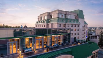 Un hôtel doté d’une façade en verre, d’un espace extérieur aménagé et d’un toit végétalisé.