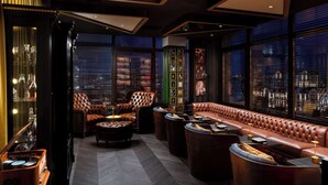 A luxurious lounge with leather seating, a bar area, and large windows offering city views. - Radisson Blu Leogrand Hotel (Chisinau)