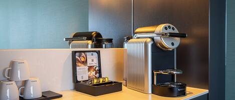 Eine moderne Kaffeestation mit Kaffeemaschine, Tassen und einer Speisekarte.