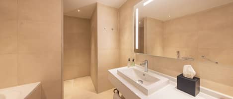 A modern bathroom with a bathtub, a sink with a mirror, and a towel rack.