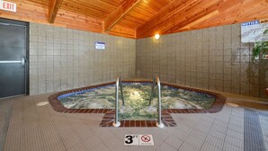 Zona de hidromasaje con vigas de madera en el techo, paredes de azulejos y un letrero que indica una profundidad máxima de 3 pies.