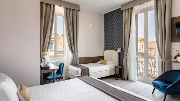 Una habitación de hotel con cama, escritorio, silla y televisión.