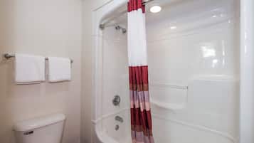 A bathroom with a bathtub, toilet, and two towels on a rack.