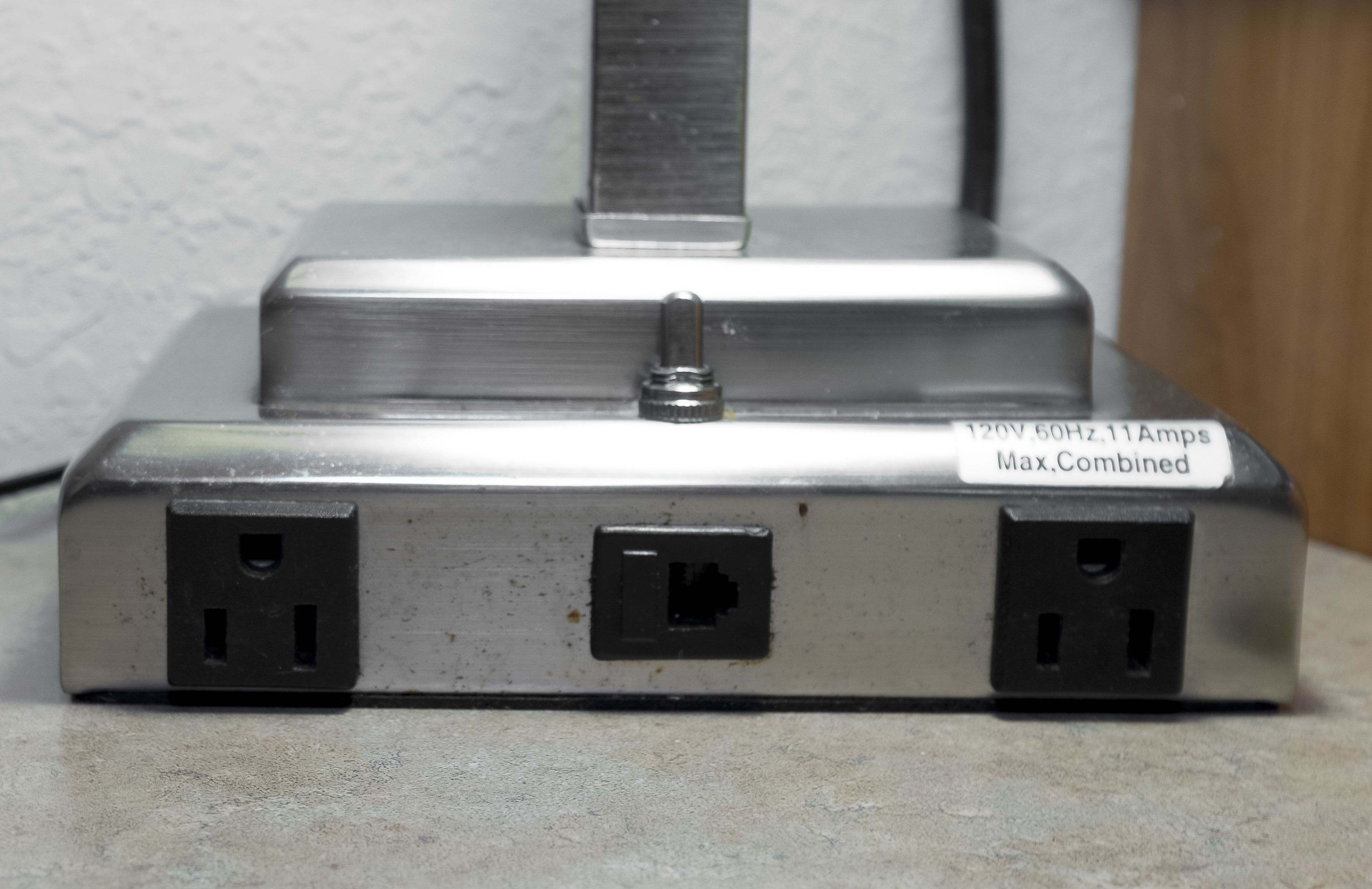 A power strip with two black sockets and a label indicating '120V 60Hz 11 Amps Max Combined'.
