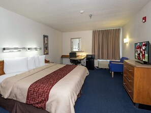 A hotel room with a bed, desk, chair, television, and a mirror. - Red Roof Inn Jackson, OH (Jackson)