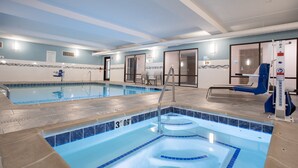 A swimming pool with a tiled edge, a lifeguard chair, and a pool ladder. - Holiday Inn Express & Suites Grand Junction by IHG (Grand Junction)
