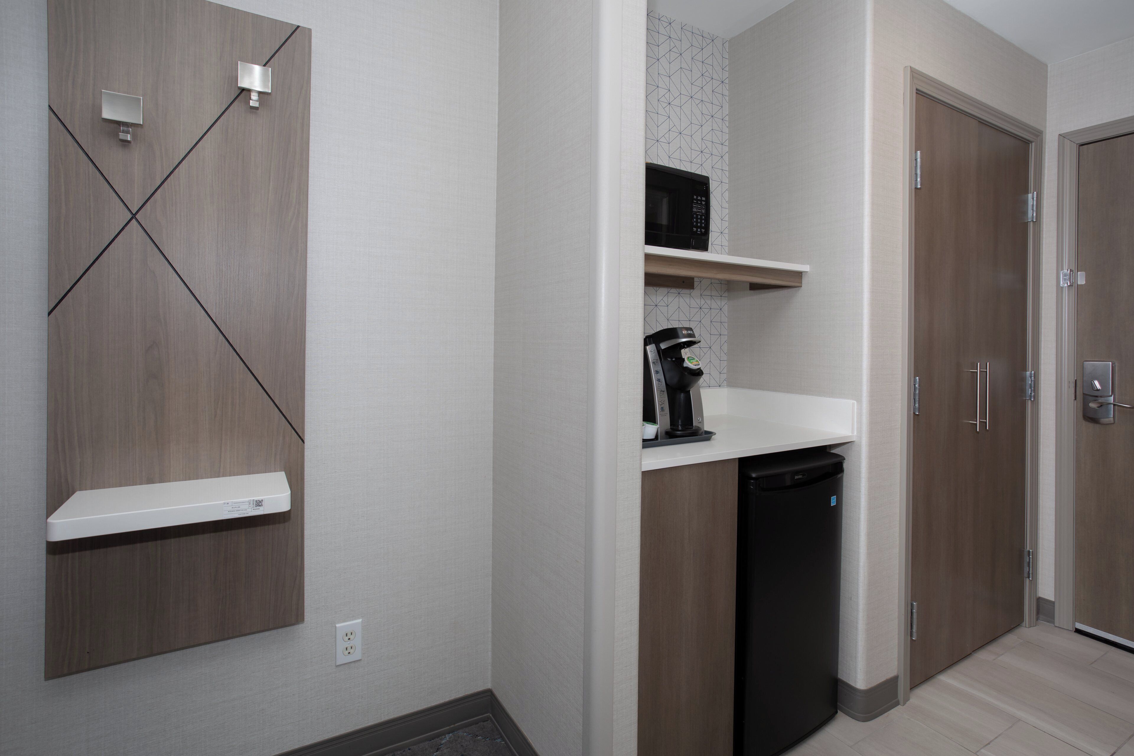 A compact kitchen with a microwave, coffee maker, and dishwasher.