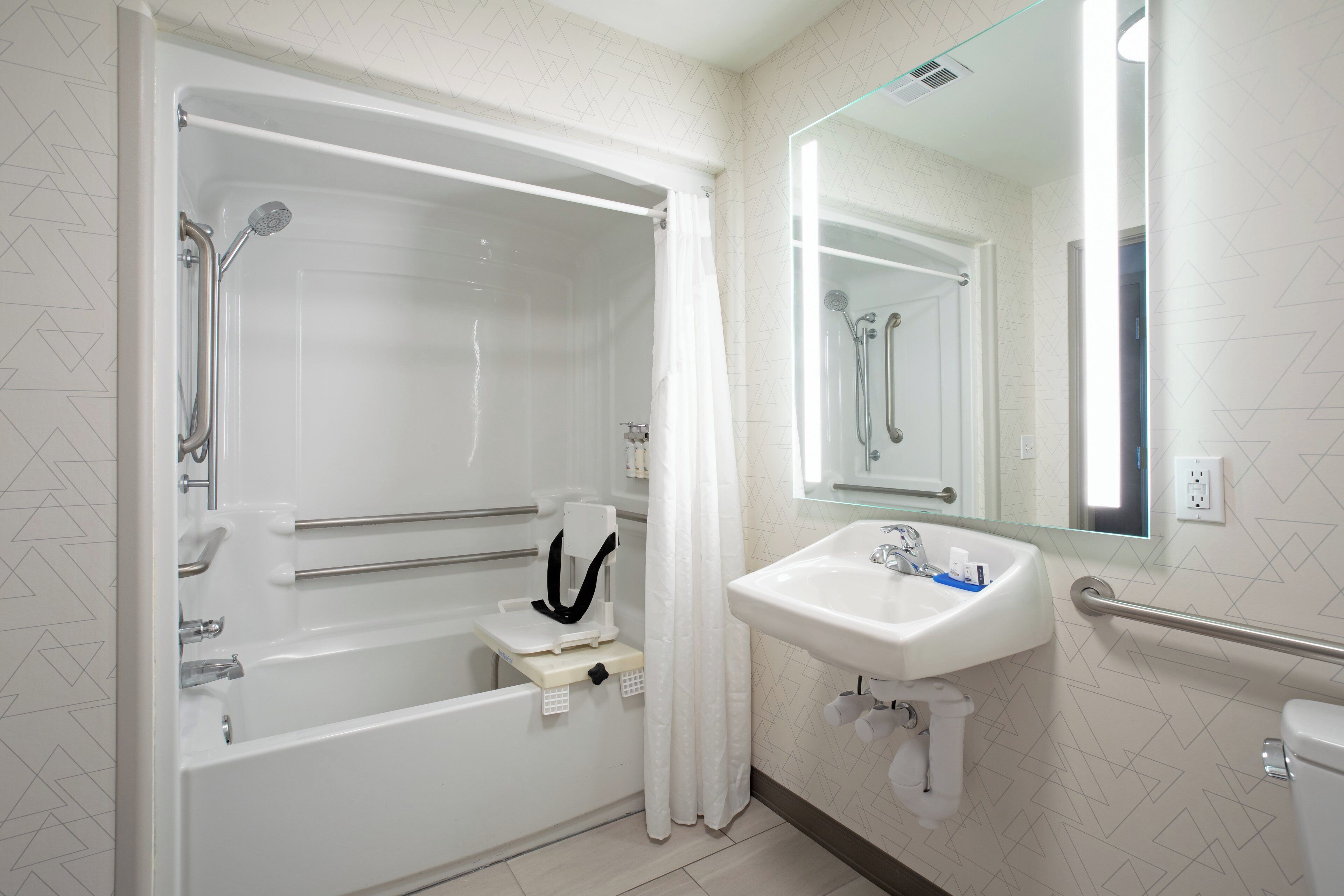 Un baño con bañera, lavamanos, inodoro y ducha.