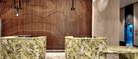 A reception area with marble counters and a wooden slatted wall.