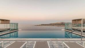 A pool with a view of the sea and a rocky island. - AX ODYCY Hotel (St. Paul's Bay)