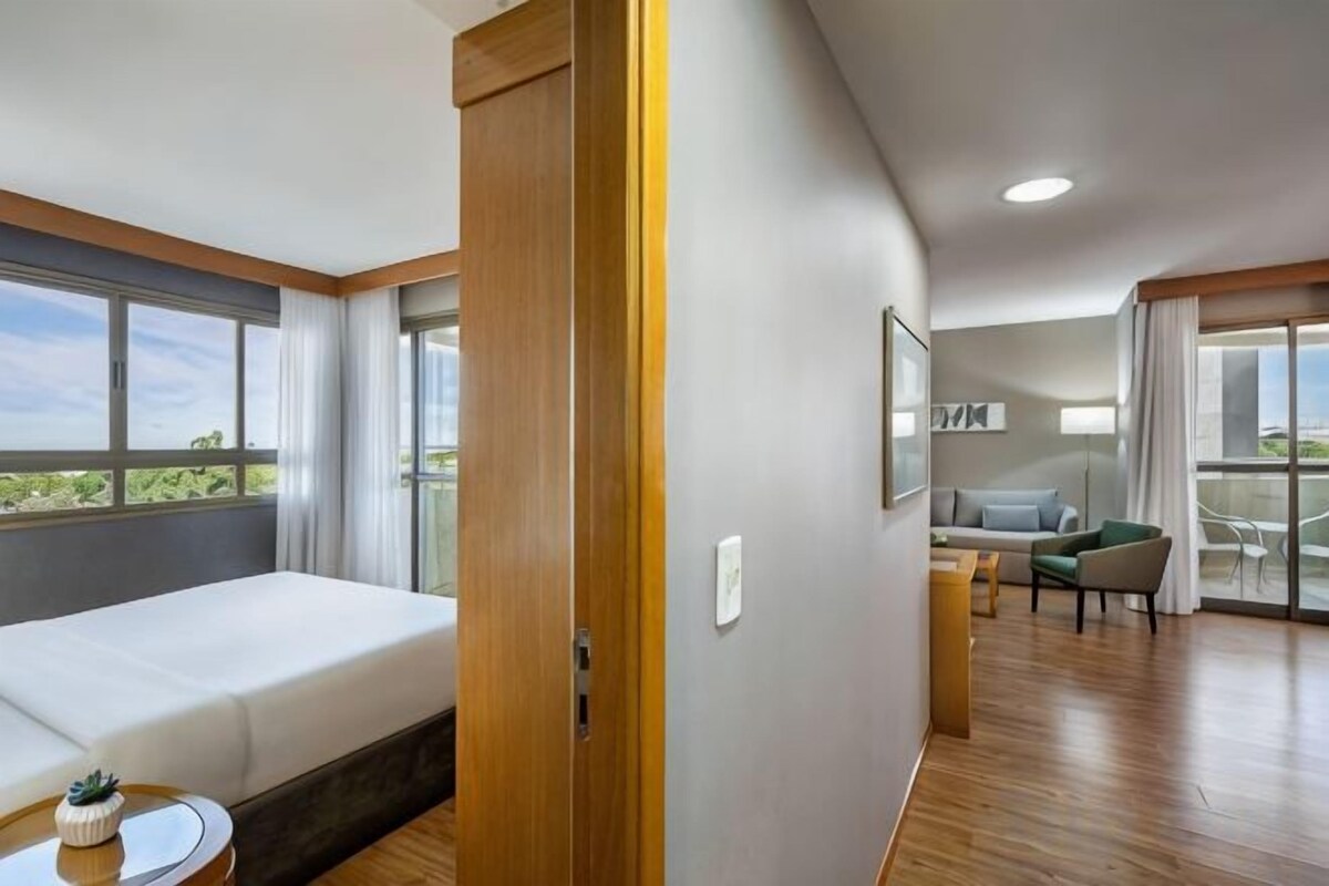 Une chambre d’hôtel avec un lit, une petite table, un canapé et un balcon avec vue.