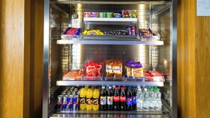 Máquina expendedora llena de aperitivos, chocolates y bebidas.