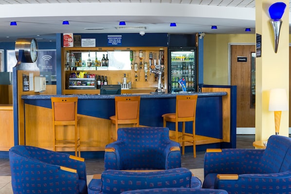 A bar area with seating, a clock, and a sign indicating free Wi-Fi.