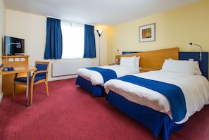 A hotel room with two beds, a desk, a chair, a TV, and a window with curtains. - Holiday Inn Express Bradford City Centre by IHG (Bradford)