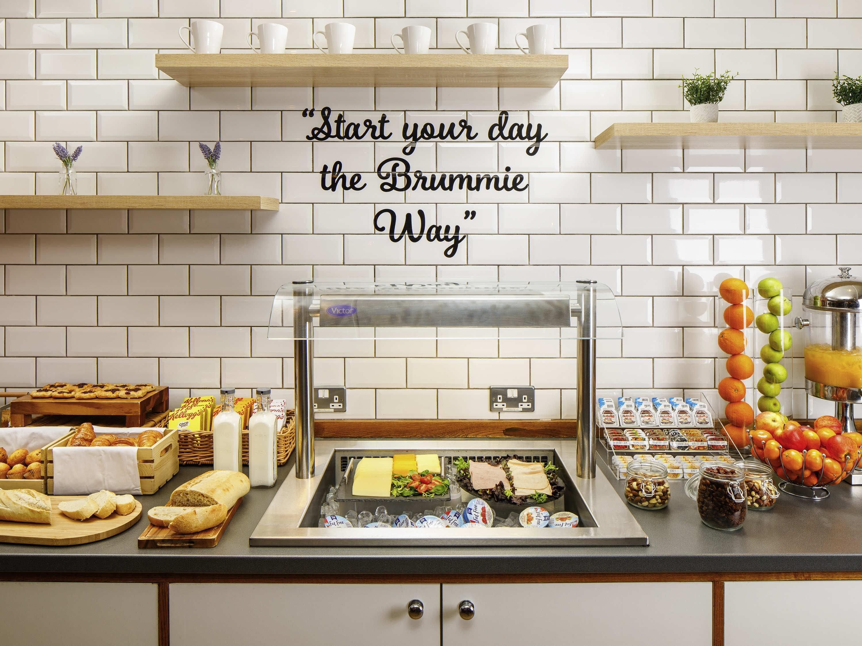 A breakfast buffet with various food items and a quote on the wall.
