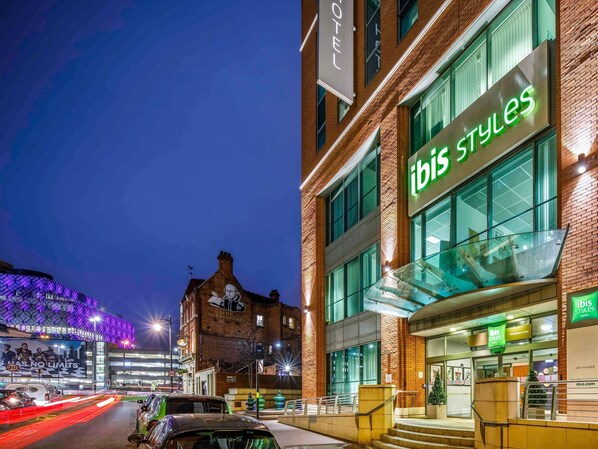 A hotel with a modern facade, a prominent 'ibis Styles' sign, and a classic building with 'The Shakespeare' sign in the background. - ibis Styles Birmingham Centre (Birmingham)