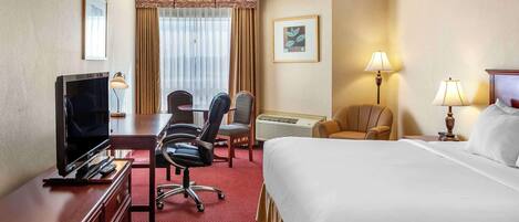 A hotel room with a bed, desk, TV, chairs, and lamps.