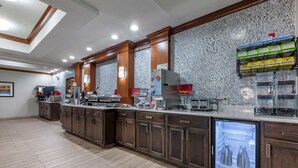 Una cocina moderna con armarios de madera, refrigerador integrado, estación de café y microondas.