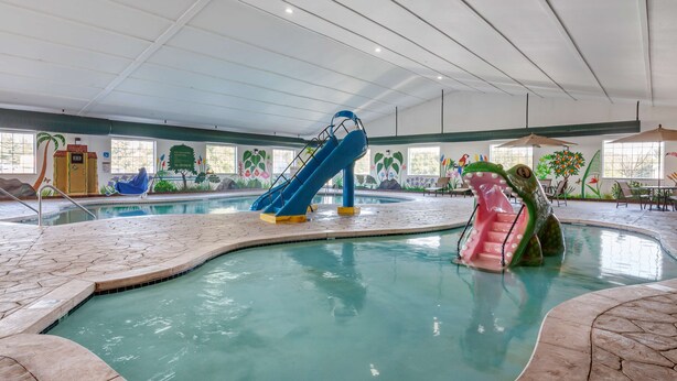 Una piscina interior con toboganes y una fuente de agua.