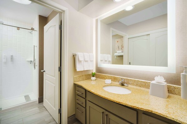 A modern bathroom with a glass shower enclosure, a sink with a granite countertop, and a large mirror. - Homewood Suites by Hilton Providence/Warwick (Warwick)
