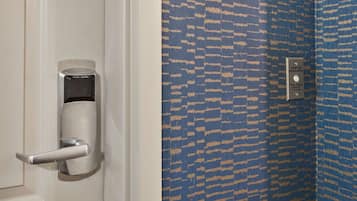 A door with a modern lock and a wall with a patterned blue and beige design.
