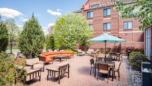 A Hilton Garden Inn with outdoor seating and a brick facade. - Hilton Garden Inn Minneapolis - Maple Grove (Maple Grove)