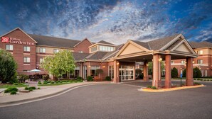 A Hilton Garden Inn with a brick facade, a covered entrance, and outdoor seating. - Hilton Garden Inn Minneapolis - Maple Grove (Maple Grove)