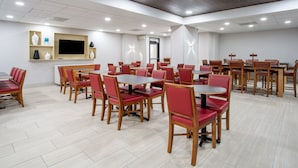 A conference room with multiple tables and chairs, a flat-screen TV, and a wooden ceiling. - Holiday Inn Express & Suites Fort Wayne by IHG (Fort Wayne)