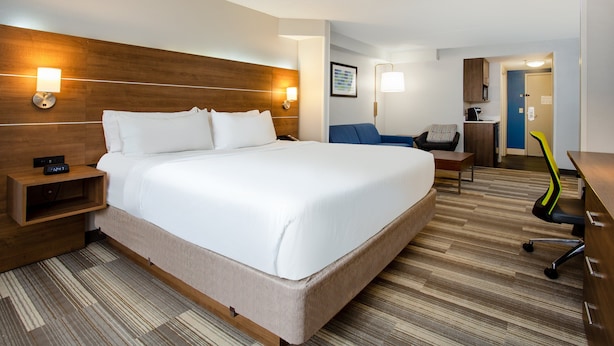 A hotel room with a large bed, bedside tables, a desk, and a chair. - Holiday Inn Express & Suites Fort Wayne by IHG (Fort Wayne)