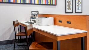 A hotel workspace with a desk, chair, laptop, and printer. - Holiday Inn Express & Suites Fort Wayne by IHG (Fort Wayne)