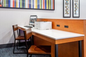 A hotel workspace with a desk, chair, laptop, and printer. - Holiday Inn Express & Suites Fort Wayne by IHG (Fort Wayne)
