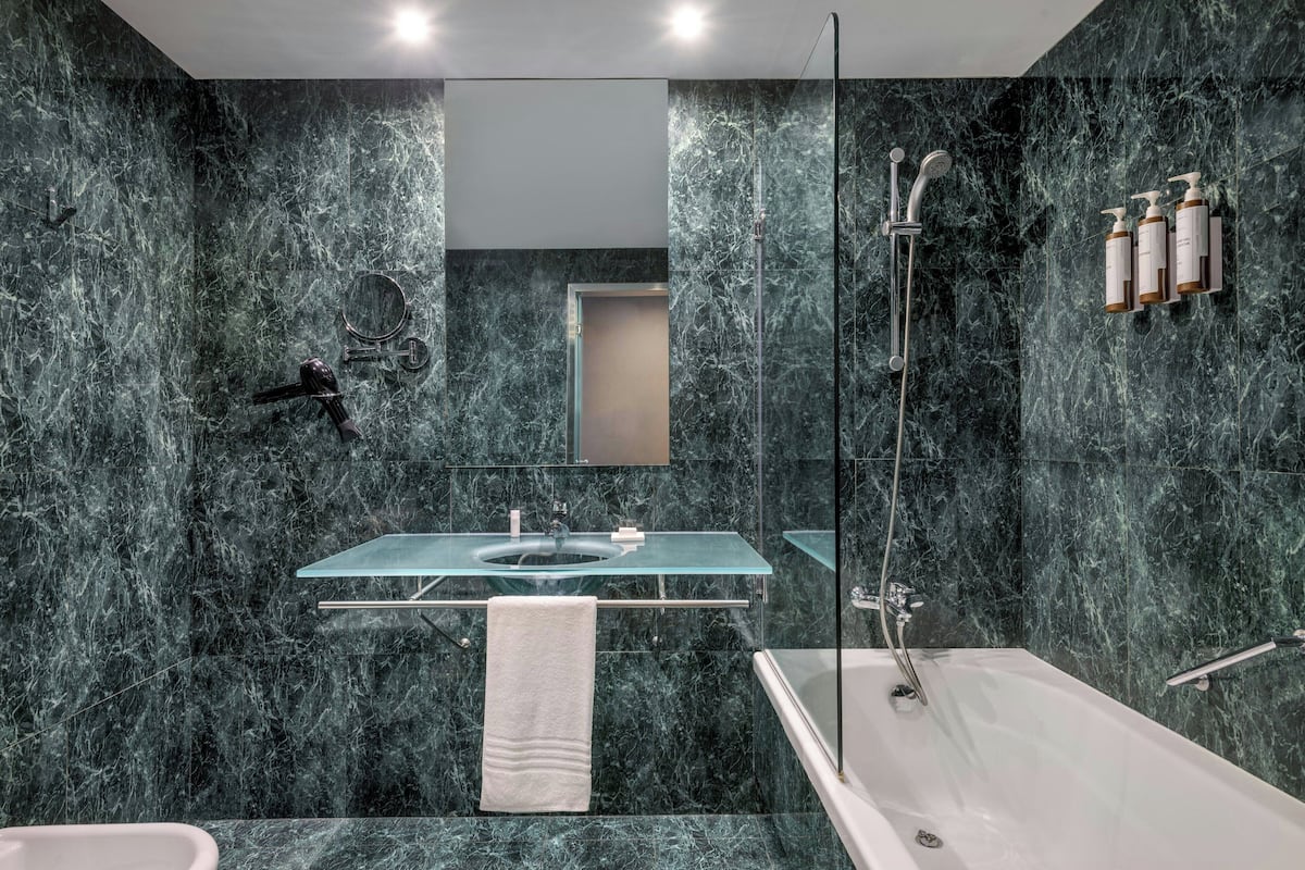 combined shower/bathtub, designer toiletries, hair dryer, towels