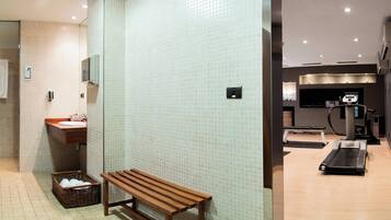 Bathroom features a sink, mirror, and tiled wall, with a bench and wicker basket.