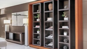 Un intérieur moderne avec une bibliothèque en bois foncé, un canapé blanc et une lampe.