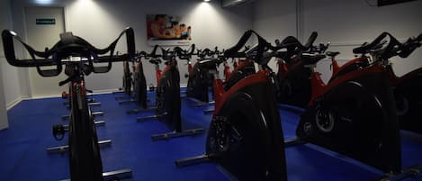 Un gimnasio con bicicletas estáticas dispuestas en filas.
