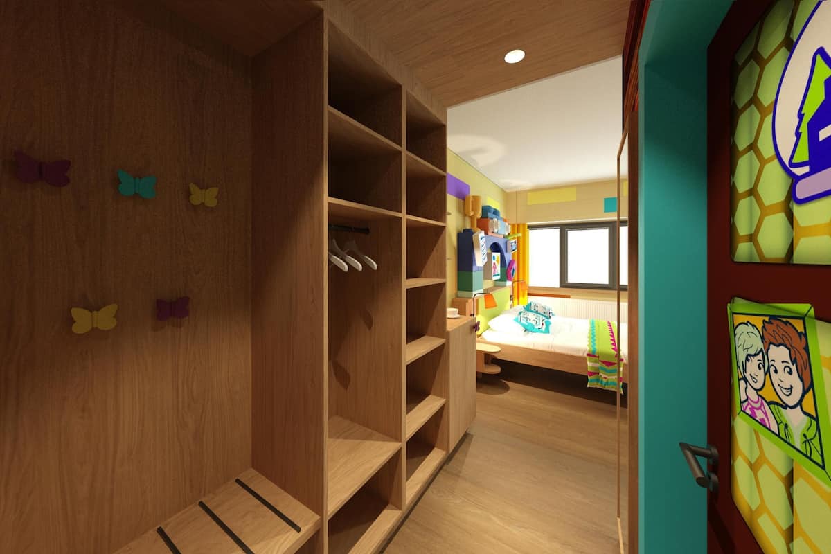 A children's room with a wooden wardrobe, a bed, and colorful wall decorations.
