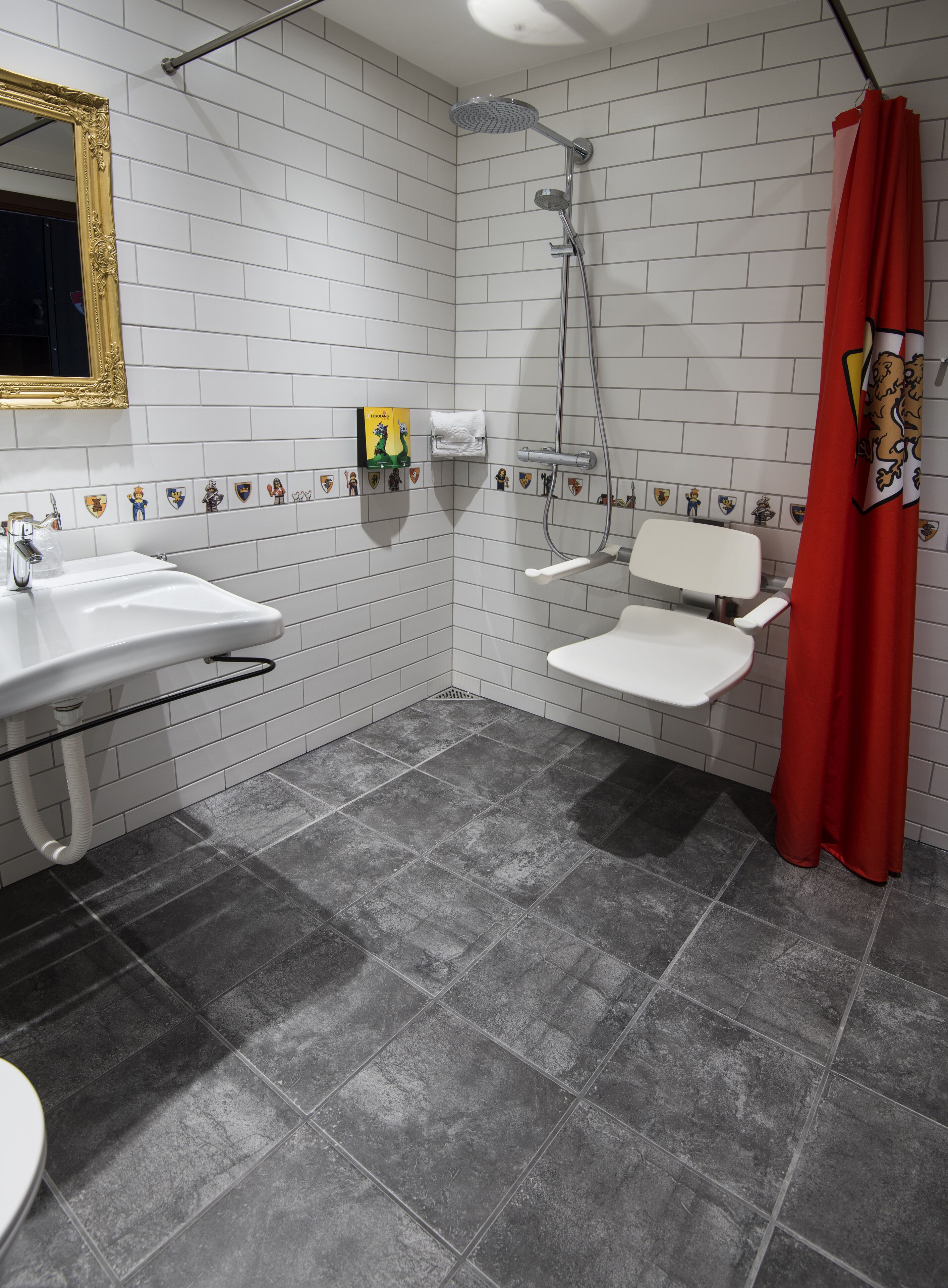 A bathroom with a white sink, a shower, and a toilet.