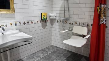 Une salle de bain avec un lavabo blanc, une douche et des toilettes.
