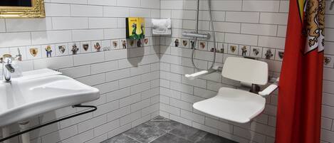 A bathroom with a white sink, a shower, and a toilet.